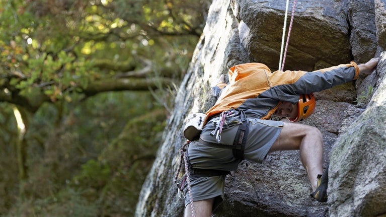 Man climbs on rocks in the summertime